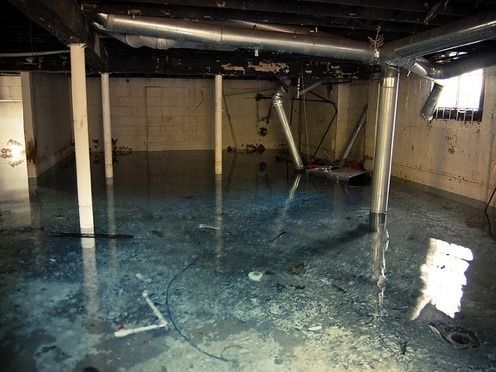 Flooded basement with standing water around structural columns